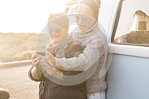 Couple of senior old caucasian people traveler taking selfie phone picture or doing conference with friends or parents standing in