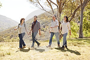 Couple and senior parents smiling during a mountain walk