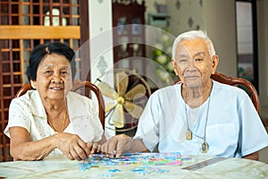 Couple senior playing with a jigsaw puzzle at home