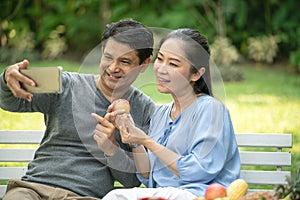 Couple senior using a mobile phone taking a picture together while having a dinner outdoor. Happy retirement people with