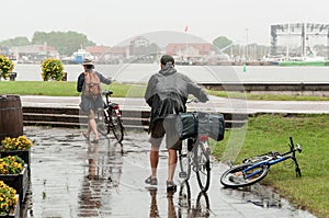 Couple seniors of cyclists in rainy day