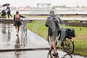 Couple seniors of cyclists in rainy day