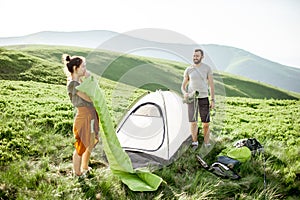 Couple setting up the tent in the mountains