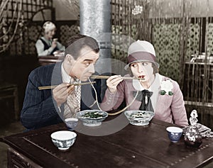 Couple sharing a noodle in a restaurant photo