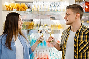 Couple at shelf with wineglasses, houseware store