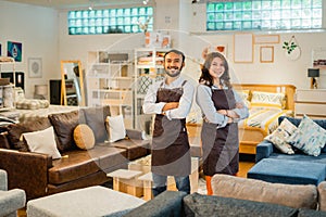 couple of shop clerks in aprons with arms crossed in furniture store