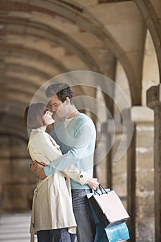 Couple With Shopping Bags Embracing