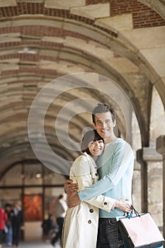 Couple With Shopping Bags Embracing