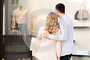 Couple with shopping bags looking at shop window