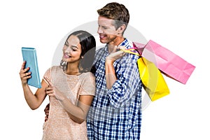 Couple with shopping bags looking at tablet PC