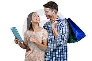 Couple with shopping bags using digital tablet