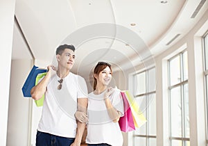 couple with shopping bags walking in mall
