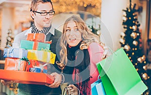 Couple shopping Christmas presents and bags in mall