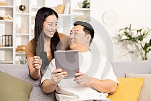 Couple Shopping Online Together on a Comfortable Sofa