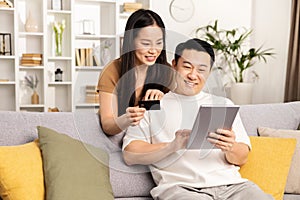 Couple Shopping Online Together On Tablet At Home