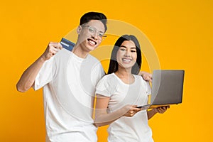 Couple shopping online, using laptop and credit card