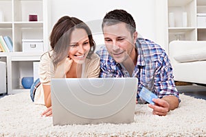 Couple shopping online using laptop and credit card