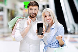 Couple Showing Cellphone Screen Standing In Shopping Center, Mockup