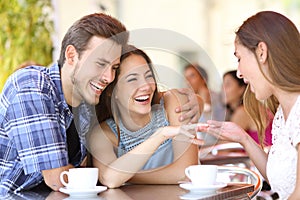 Couple showing his engagement ring to a friend