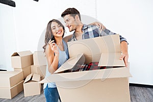 Couple showing keys to new home and hugging