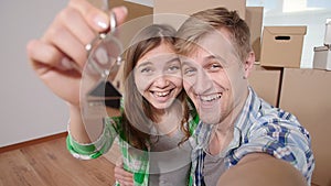 Couple showing keys to new home and selfie