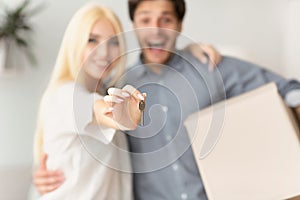 Couple Showing New House Keys Hugging Indoor, Shallow Depth