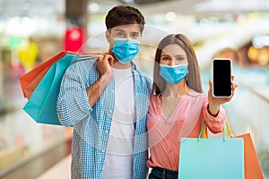 Couple Showing Phone Screen For Shopping Application Advertisement In Mall