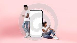 Couple showing white empty smartphone screen and texting