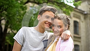 Couple of shy happy teenagers embracing, first relationship, studentship