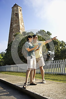 Couple sightseeing by lighthouse. photo