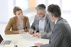 Couple signing contract in bank