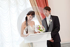 Bride and groom signing a wedding document photo