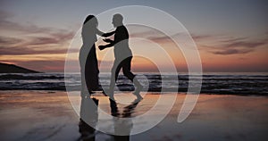 Couple, silhouette and dancing or holding hands on beach for bonding, water splash or fun outdoor evening together. Man