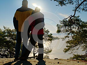 Couple silhouette. Young pair in winter walk against sun