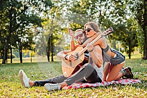 Couple singing and playing guitar on a picnic