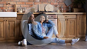 Couple sit on floor in kitchen resting at relocation day