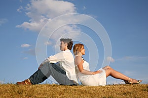 Couple sit on meadow