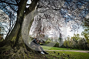 Couple sits under tree on sunset