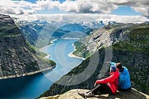 Couple sitting against amazing nature view on the way to Trolltunga. Location: Scandinavian photo