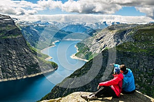 Couple sitting against amazing nature view on the way to Trolltunga. Location: Scandinavian