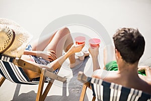 Couple sitting on armchair with cocktail drink