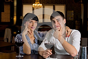 Couple sitting at the bar drinking red wine