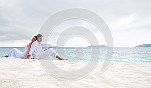 Couple sitting on the beach near the seaside