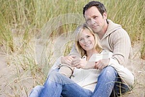 Couple sitting on beach smiling