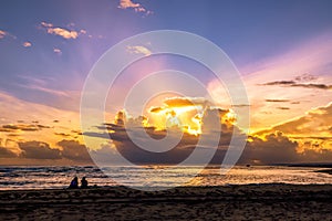 Couple sitting on the beach. Sunrise at the ocean in the Caribbean.  Puerto Plata photo