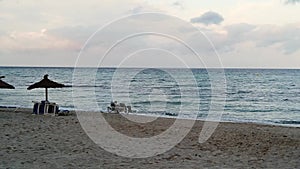 Couple sitting on the beach at sunset