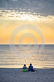 Couple sitting on the beach with view on the ocean