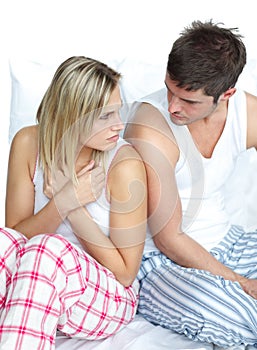 Couple sitting in bed and arguing