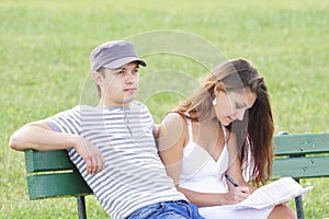 Couple sitting on bench in summer