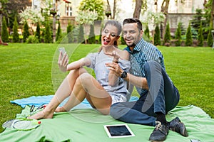 Couple sitting on the blaket, spending nice time and taking self